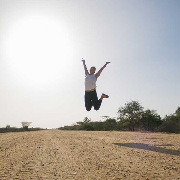A girl jumps in the air after learning how to boost energy naturally.