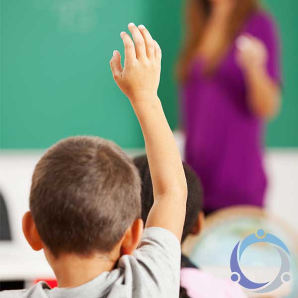 As a kid raises his hand in class, his teachers wonders how she can encourage kids helping kids.