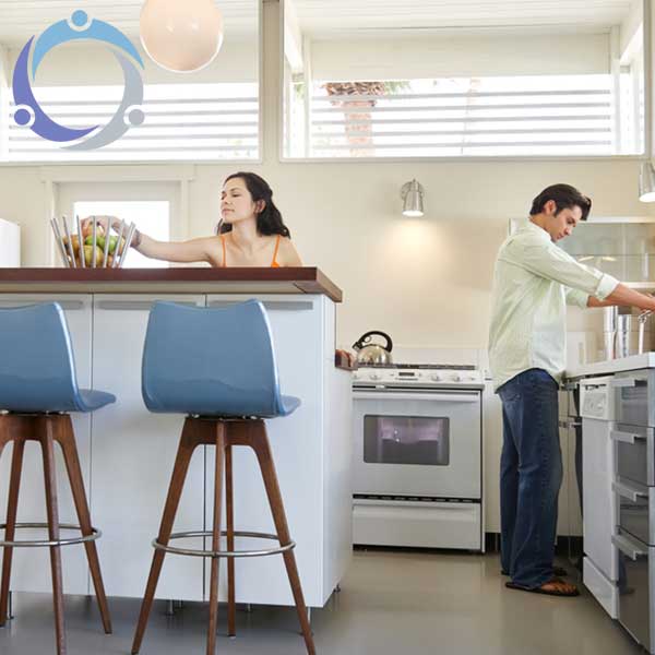 A husband and wife are cleaning their kitchen after reading how to organize your home for spring cleaning.
