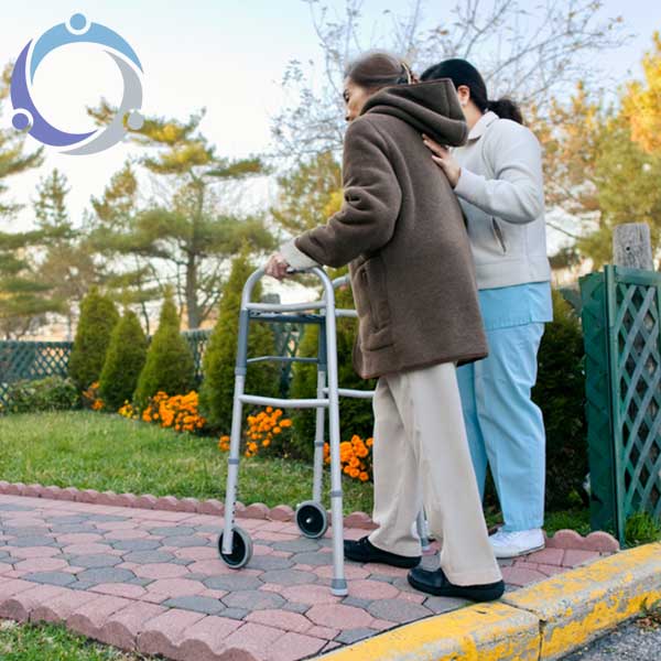 An older woman walks along with her elderly home care aide.