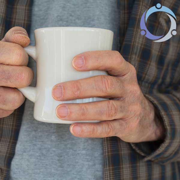 A man holds a cup of coffee contemplating if he should consider hospice care at home for his ailing father.
