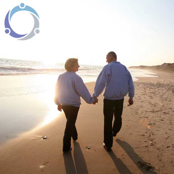 A couple walks down the beach holding hands and showing no signs of the 3 stages of Alzheimer's.