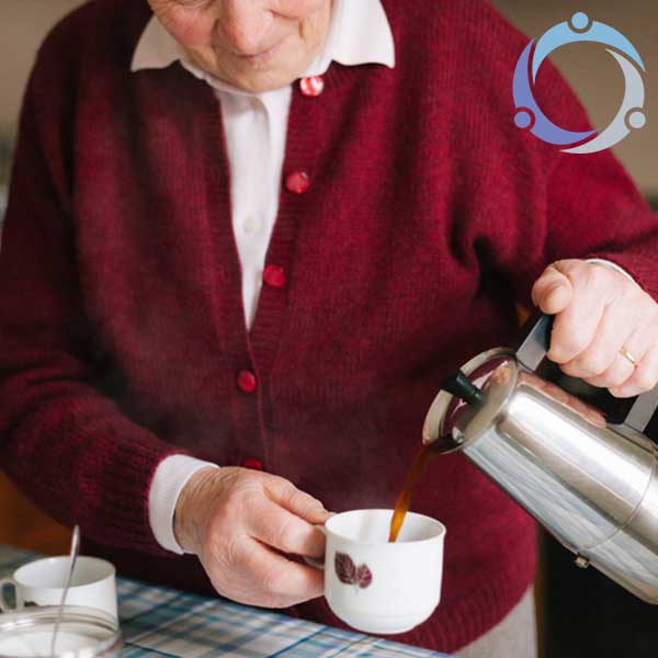 An older man pours his coffee without showing any symptoms of Alzheimer's disease.