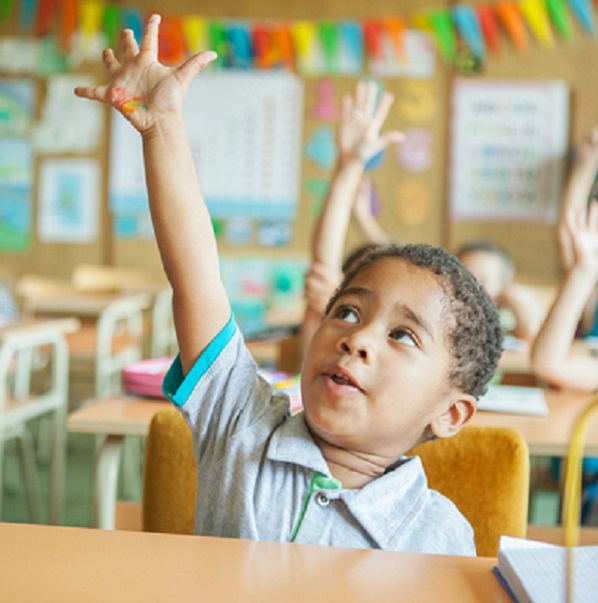 As a child raises his hand in class, he's glad his caregiver had a back to school checklist for all his needs.